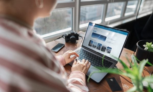 Woman paying for tickets with credit card on vacation. Online travel booking using computer. Business trip planning. Selective focus.