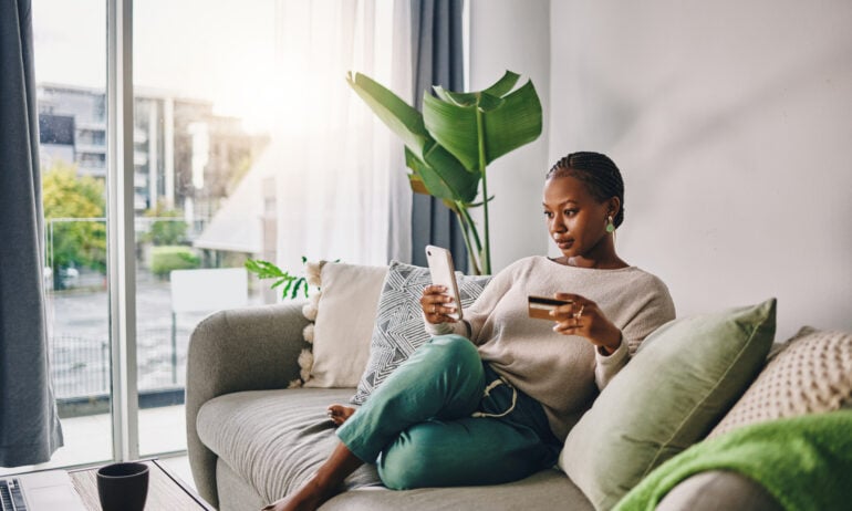 Woman sitting with phone and credit card