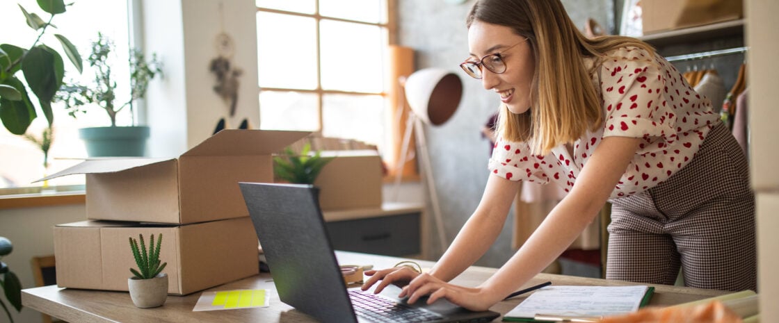 Young female entrepreneur receiving new orders in her e-commerce clothing shop