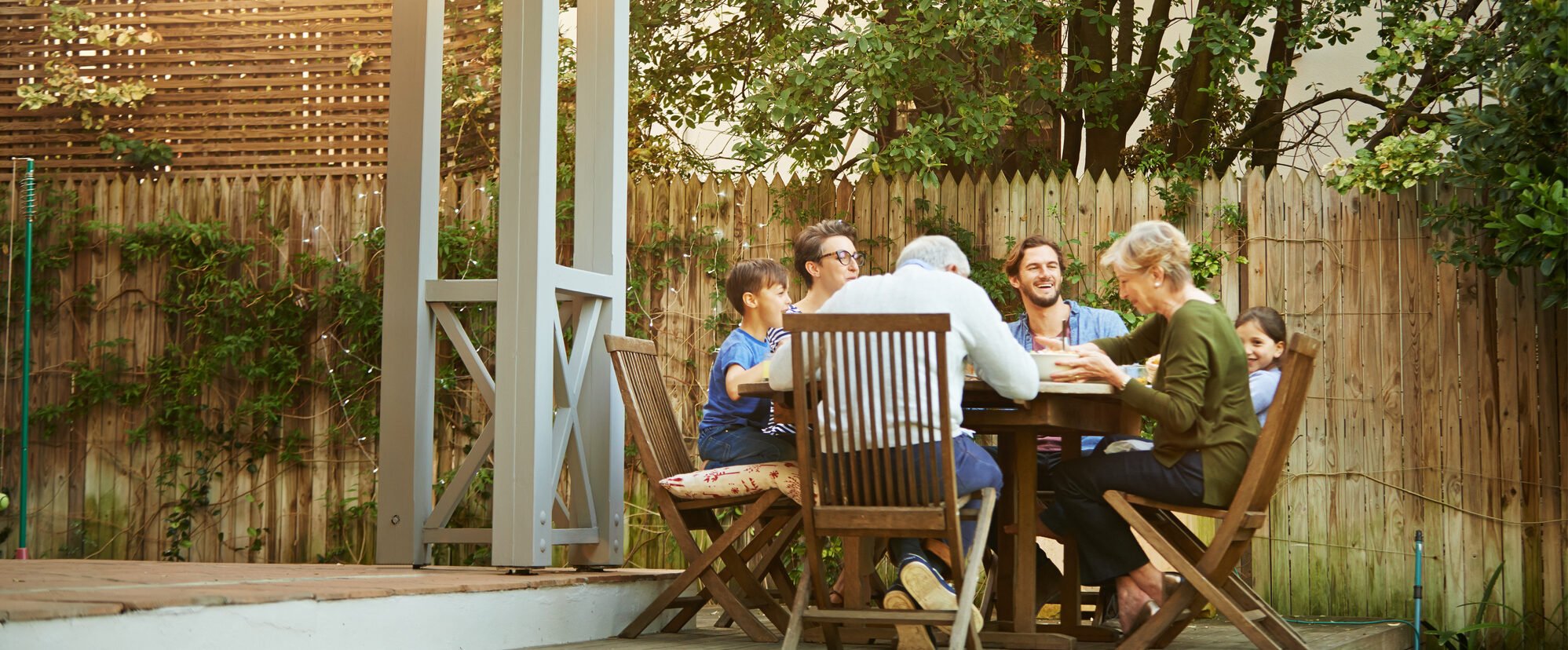 Three generations at a dinner table discussing where a high ratio mortgage is worth it.