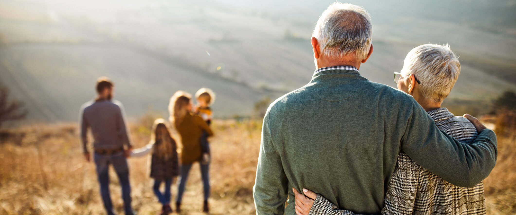 Older couple standing outdoors thinks about naming their beneficiaries.