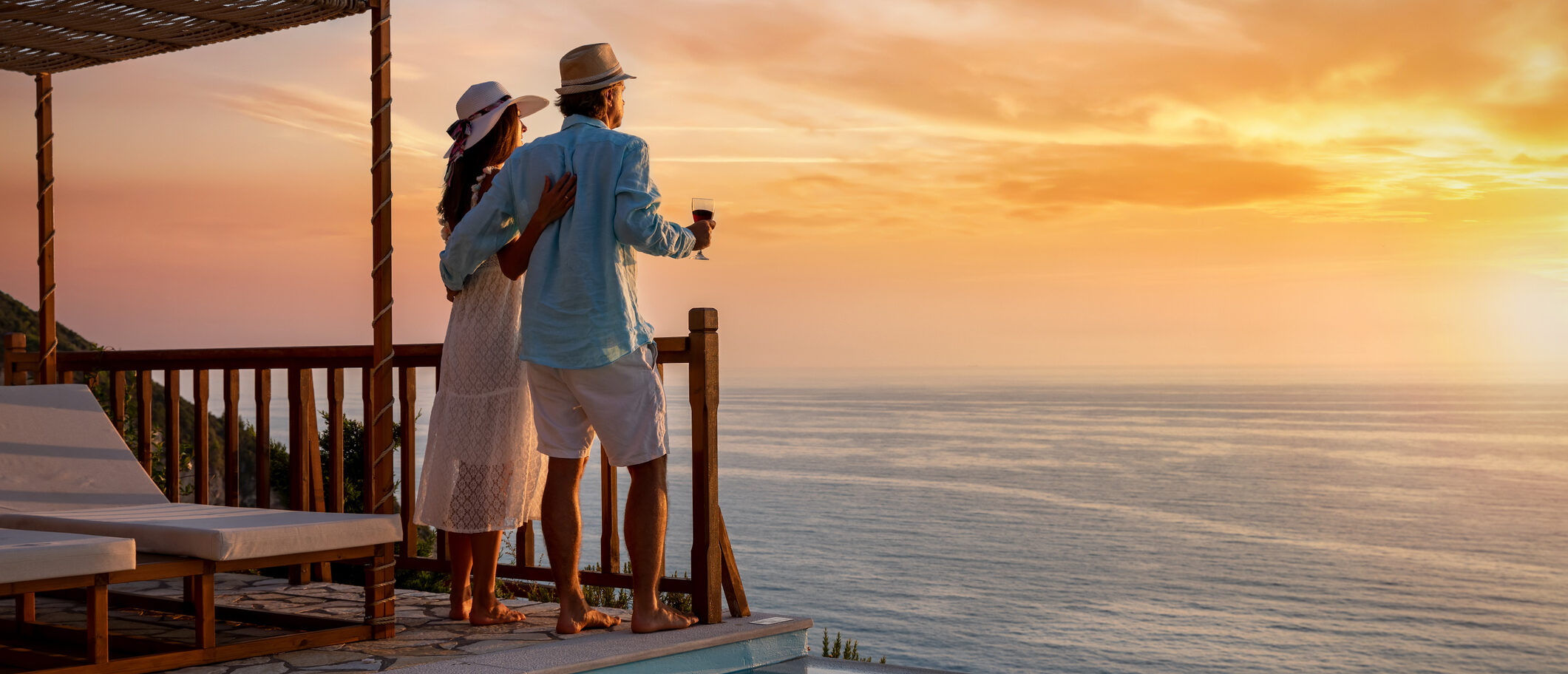 Couple enjoys a stunning sunset on a vacation booked through their black credit card.