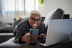 Woman banking on her phone while smiling.