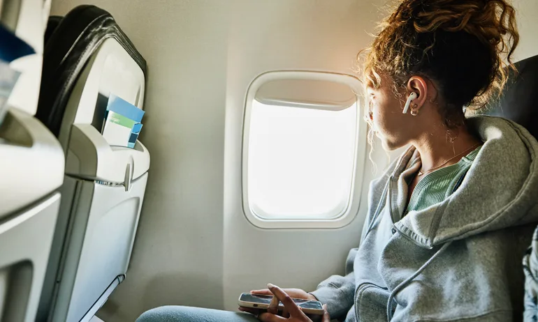 girl looking out window with american airlines basic economy ticket