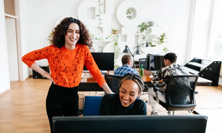 Office Manager Smiling While Chatting To Colleague