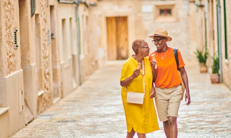 Smiling and looking around a traditional old town in Majorca Spain.