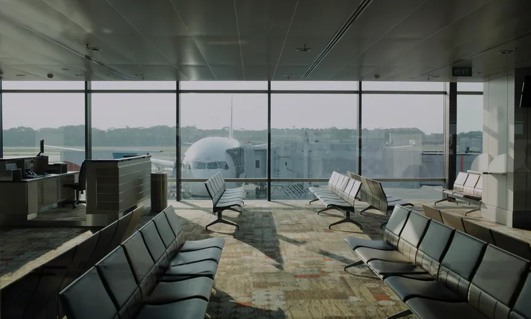 Empty airport lounge with plane outside.