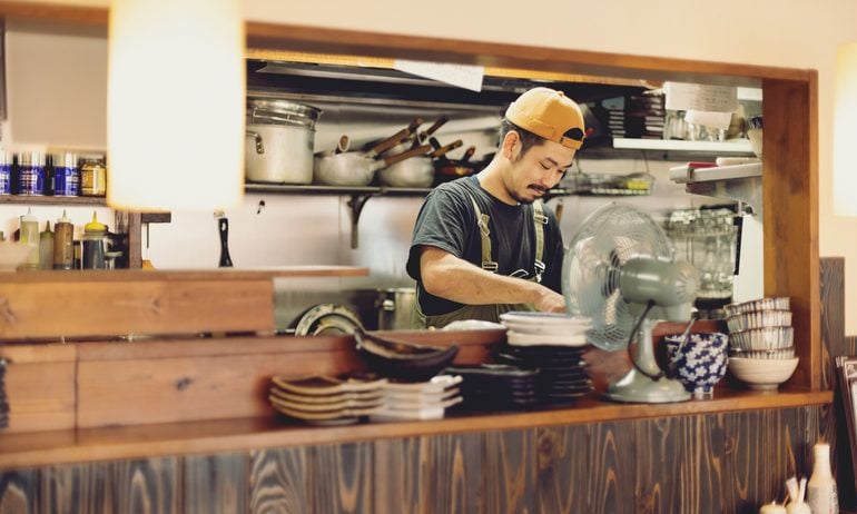 A chef preparing food in a Japanese izakaya pub