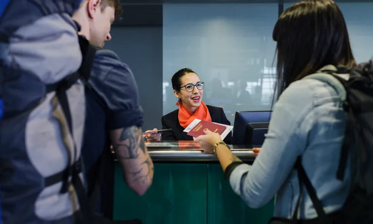 Young backpackers checking-in at airport line counter