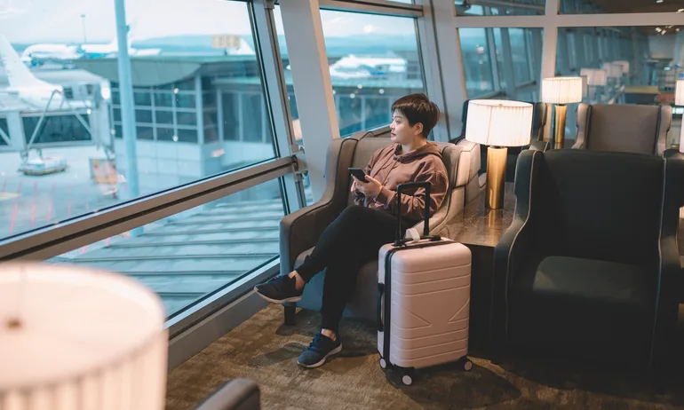 an asian chinese woman waiting her flight at airport lounge