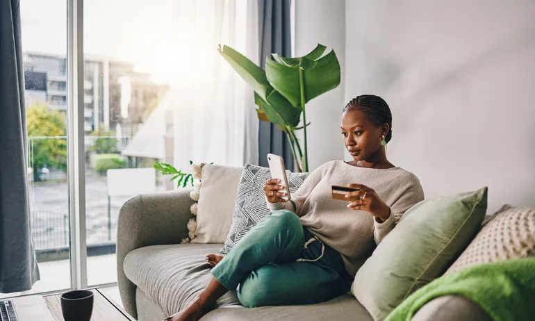 Woman sitting with phone and credit card